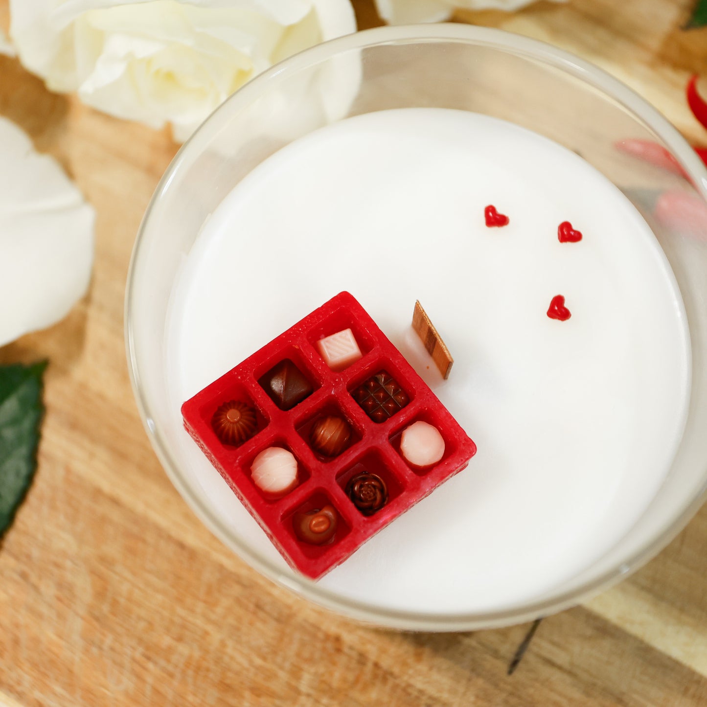 Valentine's Day 'chocolates' candle with red hearts and miniature gift box a glass container.