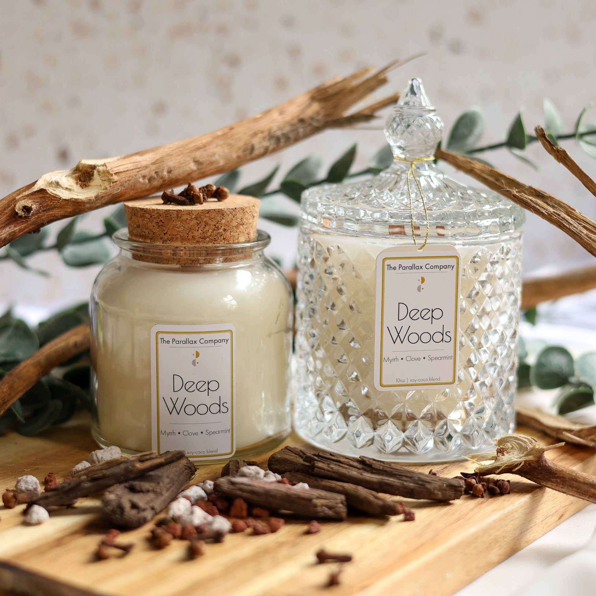 Crystal glass candle and cork-lid jar styled in woodsy twigs, Frankincense and Eucalyptus.