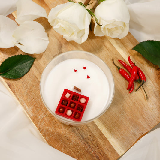 'Chocolate gift box' style wooden wick scented candle with mini red hearts surrounded by white roses and red chilli peppers.