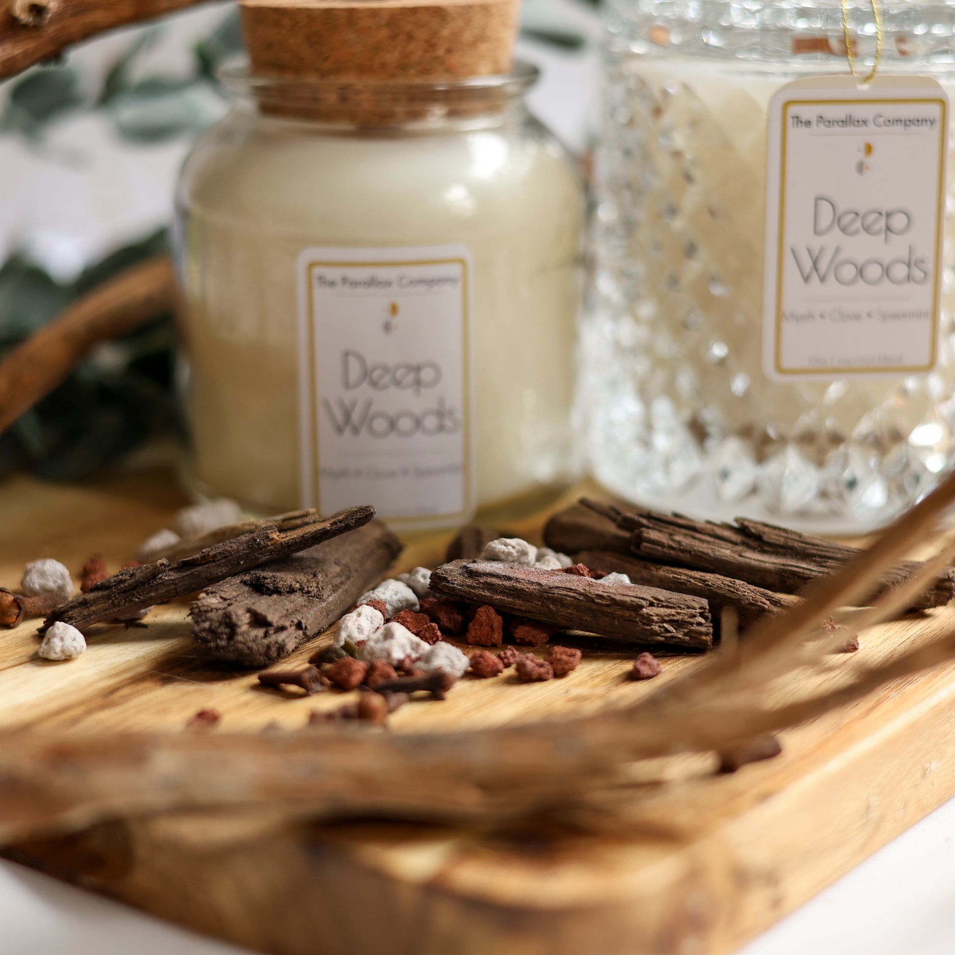 Eucalyptus leaves, Wood chips and Amber laid out on a wooden board for Masculine Fragrance Scented Candles